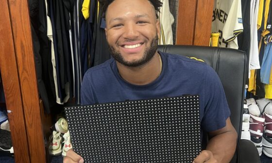 Jackson Chourio holding the scoreboard LED module that he broke with his home run yesterday