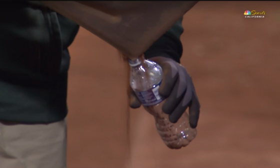 A’s grounds crew filling dirt from the Oakland Coliseum into cups  for fans