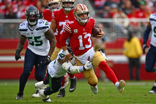 San Francisco 49ers quarterback Brock Purdy (13) runs for yardage while being tackled by Seattle Seahawks' Ernest Jones IV (13) in the first quarter of their NFL game at Levi's Stadium in Santa Clara, Calif., on Sunday, Nov. 17, 2024. (Jose Carlos Fajardo/Bay Area News Group)