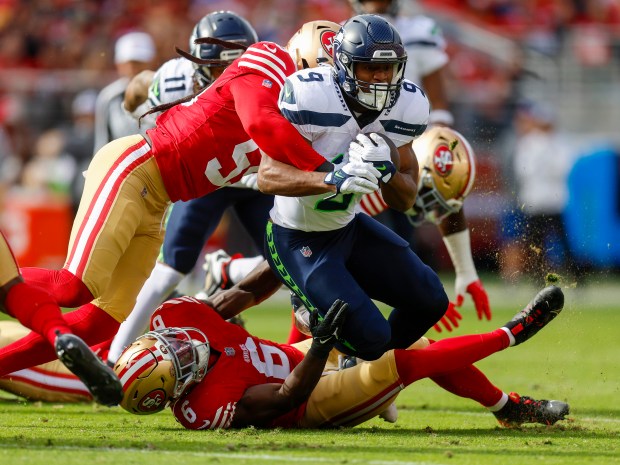 San Francisco 49ers' De'Vondre Campbell Sr. (59) and San Francisco 49ers' Malik Mustapha (6) tackle Seattle Seahawks' Kenneth Walker III (9) in the first quarter at Levi's Stadium in Santa Clara, Calif., on Sunday, Nov. 17, 2024. (Nhat V. Meyer/Bay Area News Group)