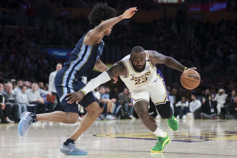 Lakers star LeBron James, right, drives against Memphis Grizzlies forward Jaylen Wells during the second half Sunday.