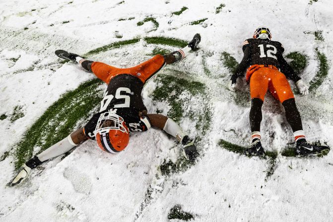 Cleveland Browns defensive end Ogbo Okoronkwo and safety Rodney McLeod Jr. make snow angels after <a href=