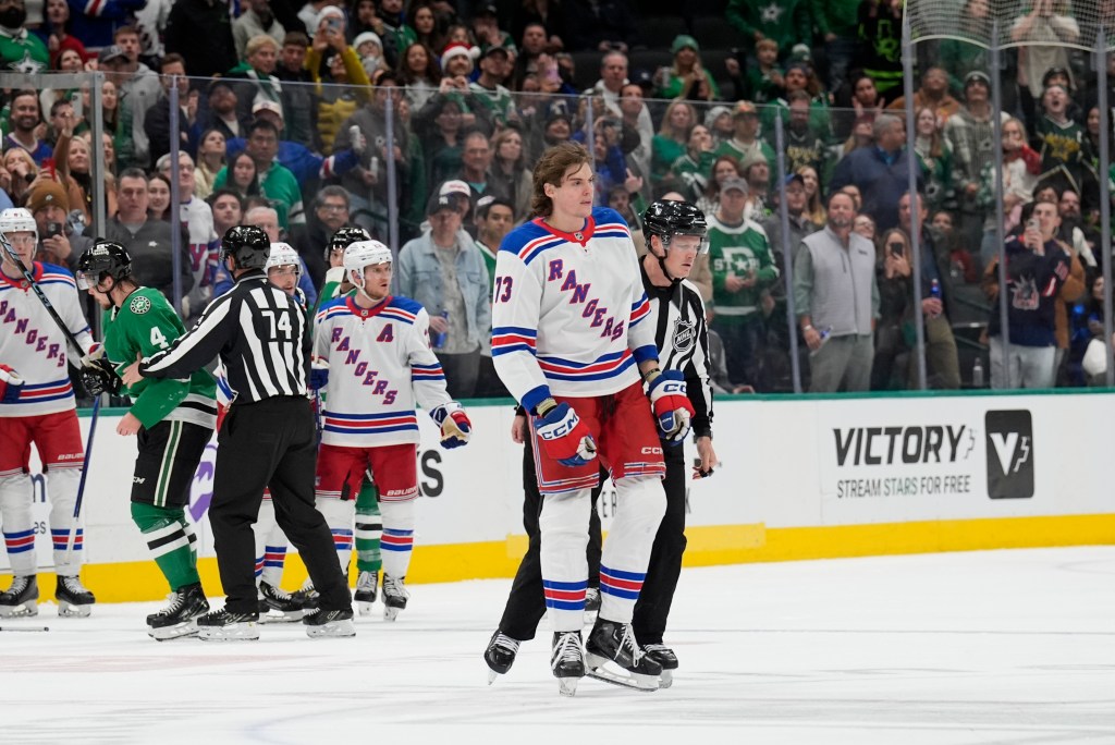 Matt Rempe #73 of the New York Rangers escorted off the ice against the Dallas Stars at the American Airlines Center on December 20, 2024 in Dallas, Texas.