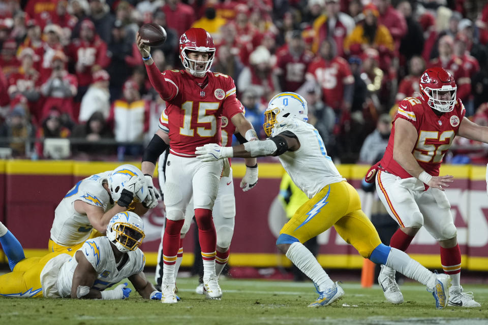 Kansas City Chiefs quarterback Patrick Mahomes (15) throws under pressure from Los Angeles Chargers linebacker Daiyan Henley (0) during the second half of an NFL football game Sunday, Dec. 8, 2024, in Kansas City, Mo. (AP Photo/Ed Zurga)