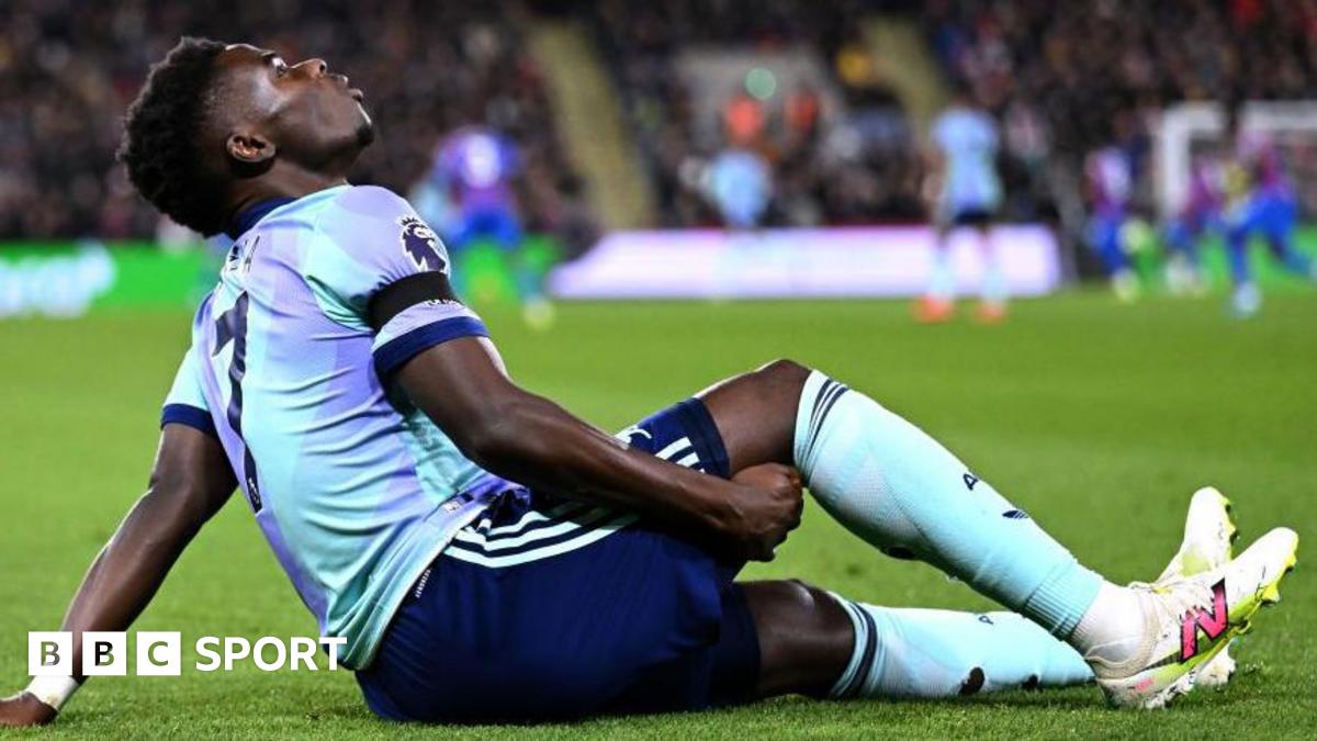 Arsenal's Bukayo Saka holds the back of his leg as he sits on the field after suffering an injury against Crystal Palace