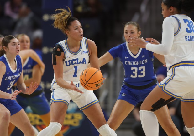 UCLA's Kiki Rice #1 passes to Angela Dugalic against Creighton's Brooke Litrell #33 at the Chase Center in San Francisco, Calif., Friday, Dec. 20, 2024. (Karl Mondon/Bay Area News Group)