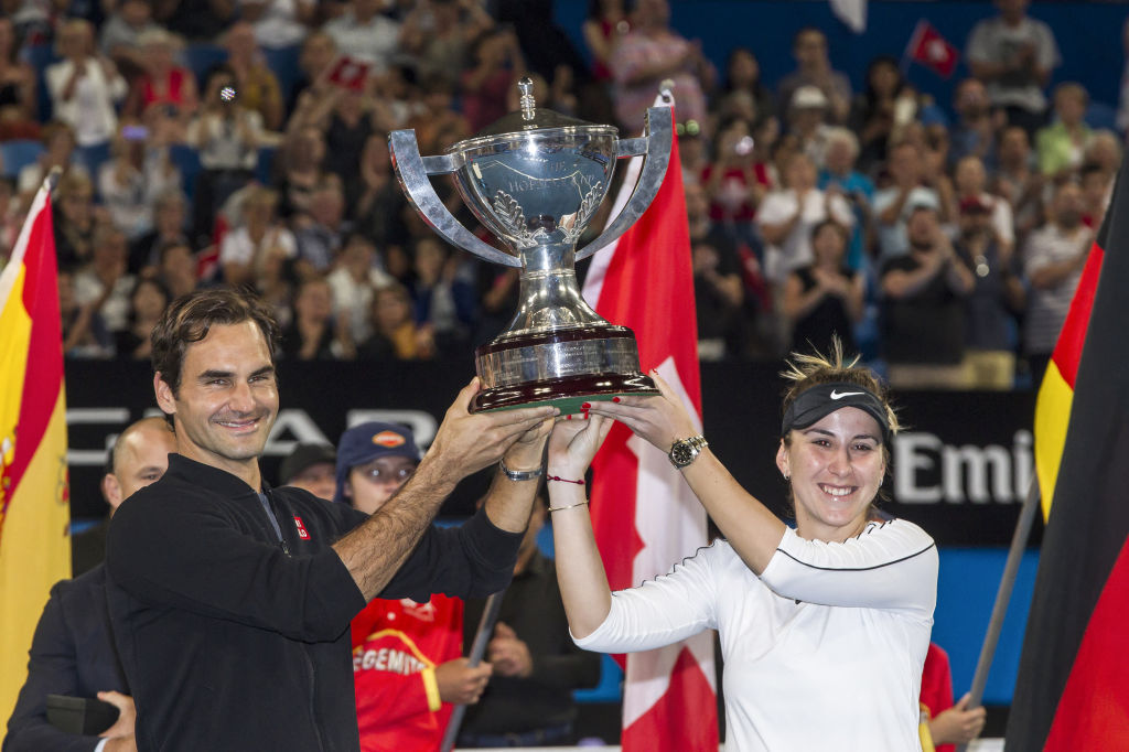 Roger Federer and his mixed doubles partner Belinda Bencic of Switzerland with the Hopman Cup after defeating runners-up Alexander Zverev and Angel...