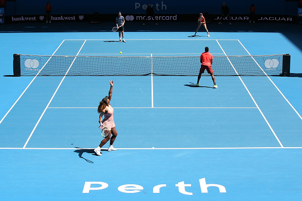 Serena Williams of the United States serves in the mixed doubles match against Katie Boulter and Cameron Norrie of Great Britain during day six of ...