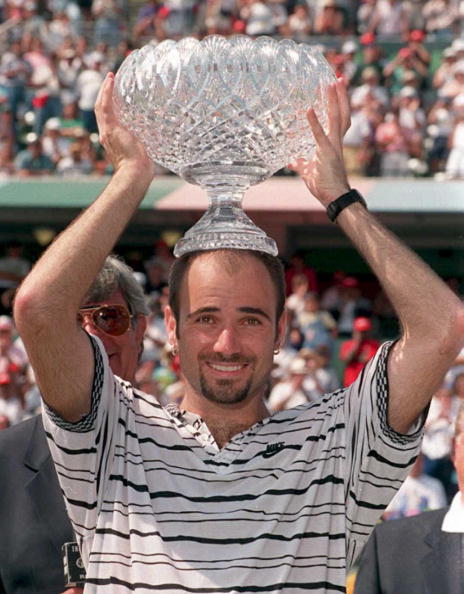 Andre Agassi of the US holds the men's singles finals trophy on his head after defeating Pete Sampras in the men's finals of The Lipton Championshi...