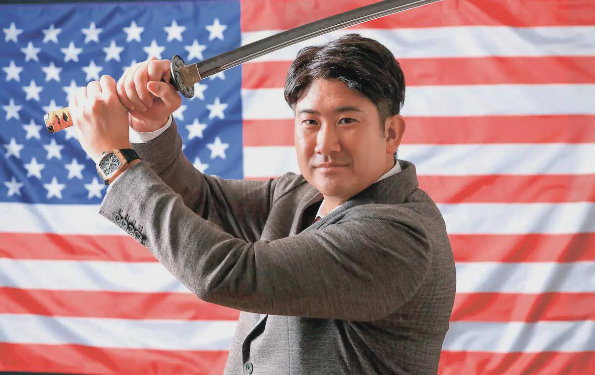 [Photo taken by Yuki Ozaki of Sponichi] New Baltimore Orioles pitcher Tomoyuki Sugano striking a pose holding a samurai replica sword with the United States flag on the background for the New Year.